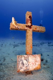 A cross erected on the seabed in memory of a diver who died in an accident, with a picture