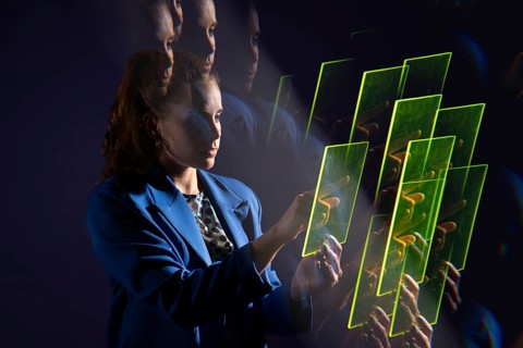 A young woman interacts with a series of transparent digital screens, symbolizing advanced