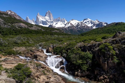 Mount Fitz Roy with snow-covered granite peaks, in front of it waterfall of a mountain stream in a
