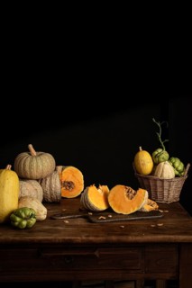 A variety of pumpkins and chayote with vibrant orange and green hues arranged on a rustic wooden