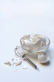Egg shells in glass bowl and whisk
