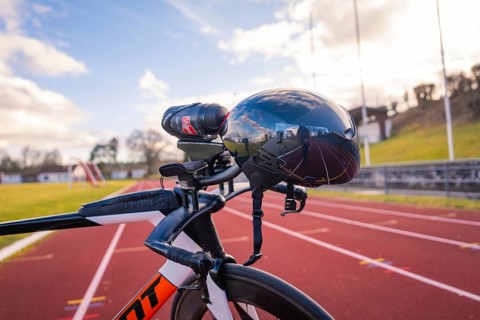 Futuristic bicycle helmet on a running track with blue sky and reflection, triathlon bike, Calw,