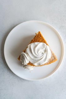 Top view of a slice of homemade honey cake topped with velvety sour cream sauce and elegantly
