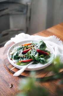 A wholesome dish featuring fresh spinach leaves, crisp apple slices, and crunchy pecan nuts,