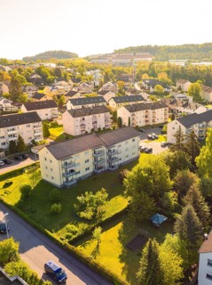 Aerial view of residential area with several apartment blocks surrounded by green meadows and