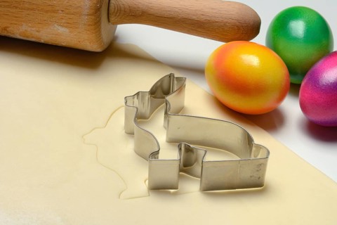 Rolled dough with bunny cookie cutter, rolling pin and Easter eggs
