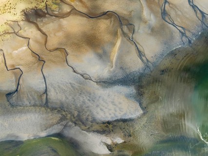Streams and marshes at low tide in the coastal wetlands of the Walvis Bay lagoon. In the distance