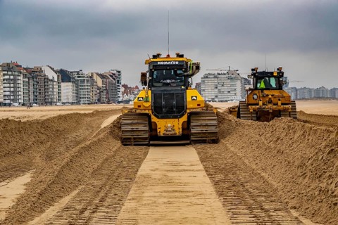 Bulldozers when distributing sand on the beach in the town of Knokke-Heist, part of coastal