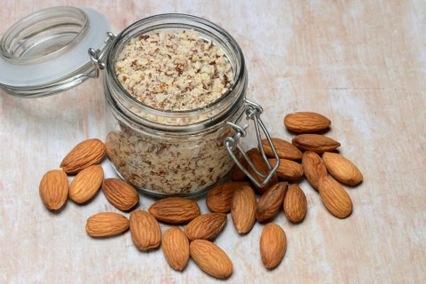 Almonds and ground almonds in glass, Prunus amygdalus