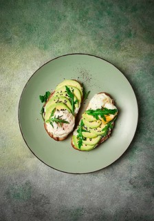 Sandwich with cream cheese, sliced avocado and boiled egg, arugula, on grainy bread, homemade,