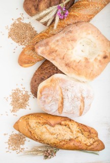 Different kinds of fresh baked bread on a white wooden background. top view, flat lay, close up