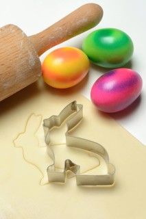 Rolled dough with bunny cookie cutter, rolling pin and Easter eggs
