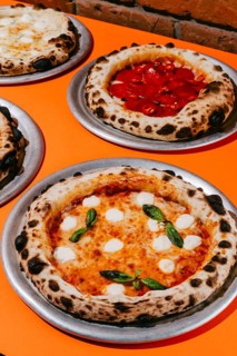 Wood-fired Margherita pizza with mozzarella, tomato sauce, basil, and oregano, paired with