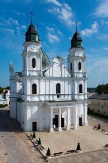 Magnificent baroque church with two white towers and detailed façade under a clear sky, Basilica of