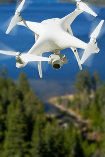 Unmanned aircraft system (UAV) quadcopter drone in the air over lake tahoe