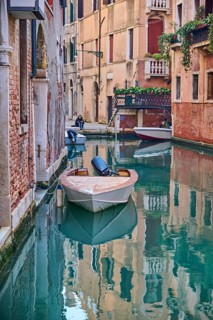 View on a waterway with boats lying in the water in Venice on a sunny day in winter, Italy