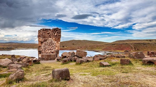 Ancient stone ruin with water and extensive landscape in the background, The Chullpas of Sillustani