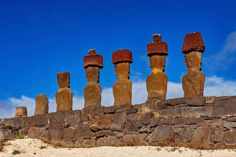 Six Moai statues on a raised stone structure on a sunny day, The Moai statues on Easter Island in