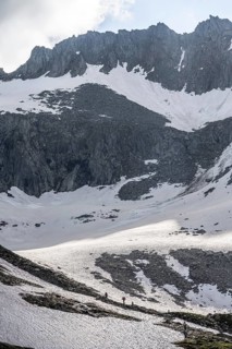 Mountain landscape with rocky ridge and snow, mountaineer climbing the Schönbichler Horn, Berliner