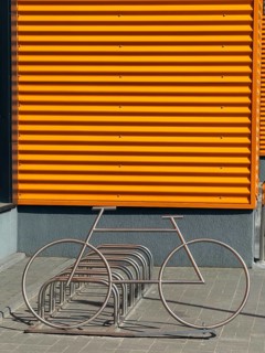 Modern industrial architecture featuring a bright orange metal wall and a creatively designed