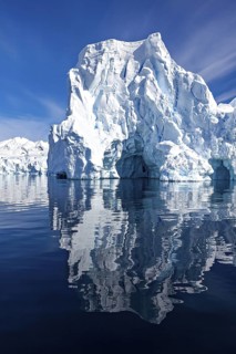 Large iceberg with impressive height reflected in the calm water, icebergs in the Southern Ocean in