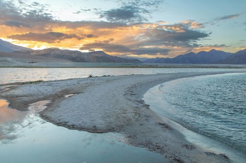 Breathtaking view of Pangong Tso lake in Ladakh at sunset. The tranquil waters reflect the vibrant