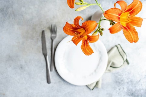 Top view of a vibrant orange tiger lily flower elegantly placed in a white vase on a minimalist