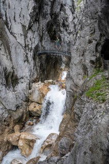 Mountaineer on a bridge over the mountain stream Hammersbach in a gorge, Höllentalklamm, Höllental,