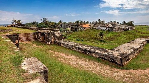Ruins of a fortress with grass and palm trees under a blue sky, The fortress of Galle in Sri Lanka