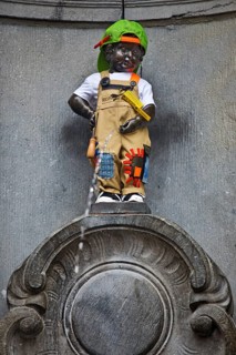 Bronze statue Manneken Pis by Jérôme Duquesnoy, fountain figure of a urinating boy in costume,