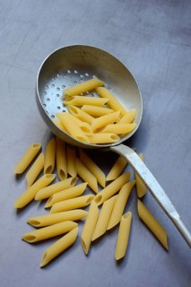 Pasta, Italian penne in a sieve ladle