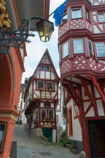 Narrow alley with striking red and white half-timbered houses and a lantern, weaving room, pointed