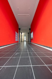 Long corridor with red walls and black tiled floor, University of Stuttgart, Germany