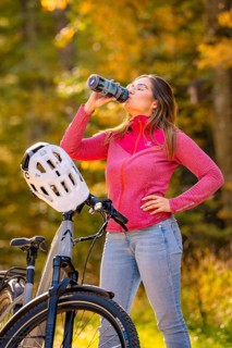 Woman drinking water with Ebike in the forest, Black Forest, Gechingen, Germany