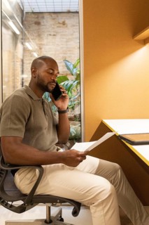 Professional working inside a modern coworking space in Barcelona. He's seated at a desk, engaged