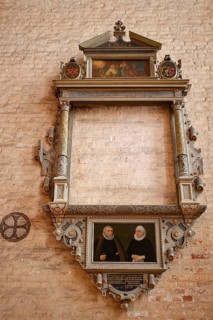 Richly decorated empty picture frame and painted paw cross to the left of it in the interior of the