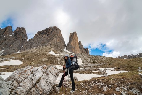 A mother with a baby in a carrier enjoying a scenic hike in the majestic Tre Cime di Lavaredo,