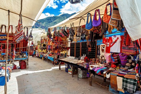 Colourful market stalls with traditional Peruvian textiles and bags under blue skies, the city of