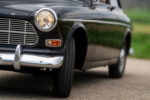 Front round front light and front section, vintage car, black Volvo Amazon, medium class car from