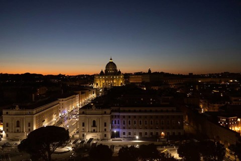 Captivating evening view of Rome's skyline, highlighting the Vatican Dome illuminated against the
