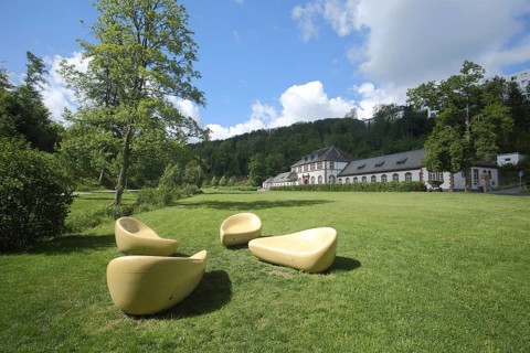 Spa garden with designer seat cushions and Art Nouveau mud bath house, yellow benches, modern art,