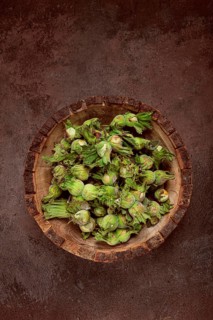 Fresh, green hazelnuts, close-up, in a wooden bowl, unpeeled, top view, no people