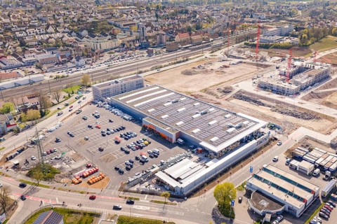 Industrial area with construction work and large buildings with solar panels, PV plant at Obi