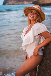 Lifestyle of a blonde Caucasian girl in a white swimsuit by the sea enjoying the summer