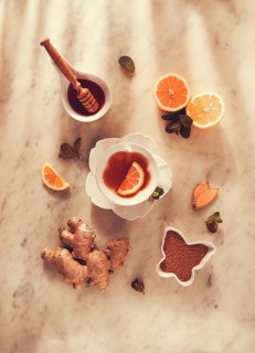Ginger tea, with lemon, mint and honey, on a marble table, top view, sunlight, no people, selective