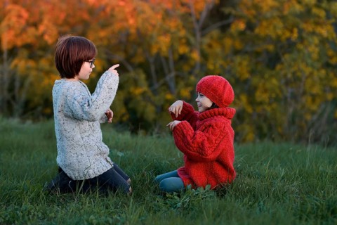 A girl and a boy, siblings, are enjoying a playful day in an autumn park, surrounded by vibrant