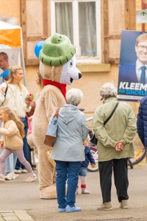 Person in a bear costume surrounded by adults and children on a street, Sindelfingen, Böblingen