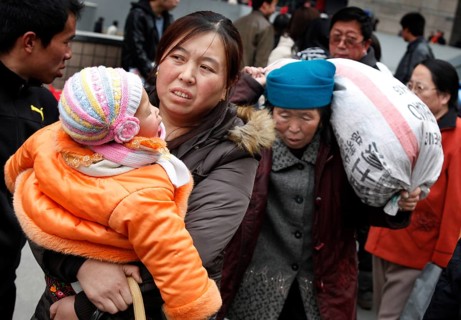Beijing, CHN, 23.02.09 - A Chinese mother carries her child in her arms to the train station,