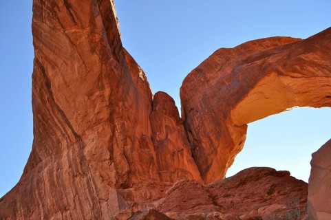 Double Arch, an imposing rock arch in close perspective under clear skies, Arches National Park,