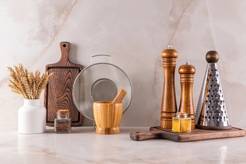 Elegant kitchen utensils arranged on a marble countertop reflecting modern interior design trends